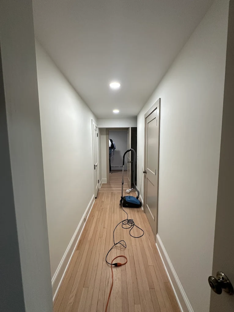 Long hallway with fresh white walls and warm gray doors