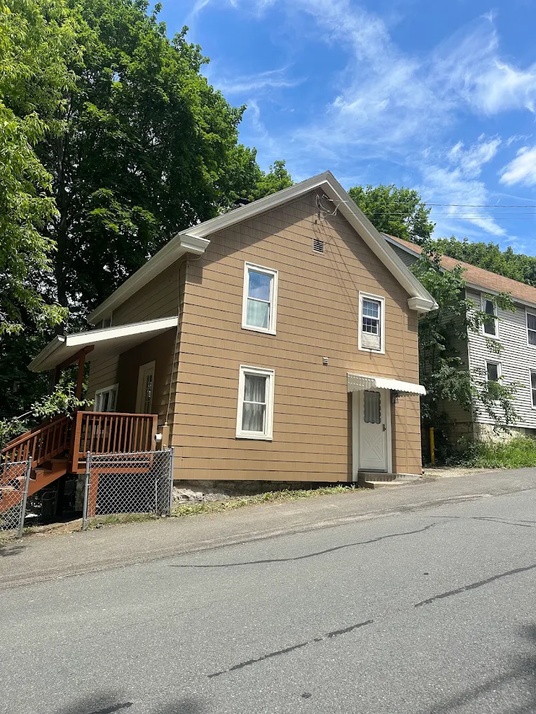 Tan two-story house with refreshed siding and white trim