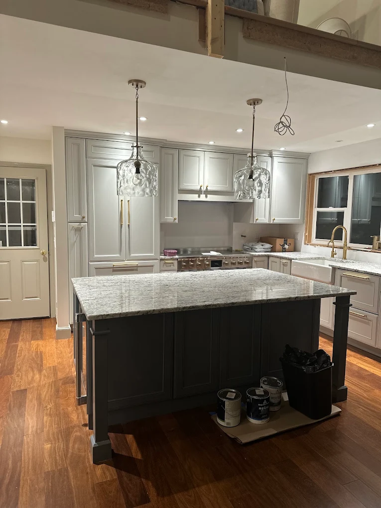 Finished kitchen with gray cabinets and dark island
