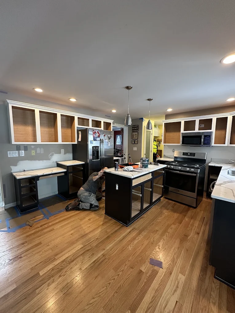 Painter working on kitchen cabinets during a refinish