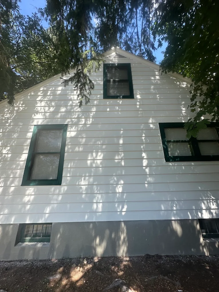 White exterior siding with dark green window trim