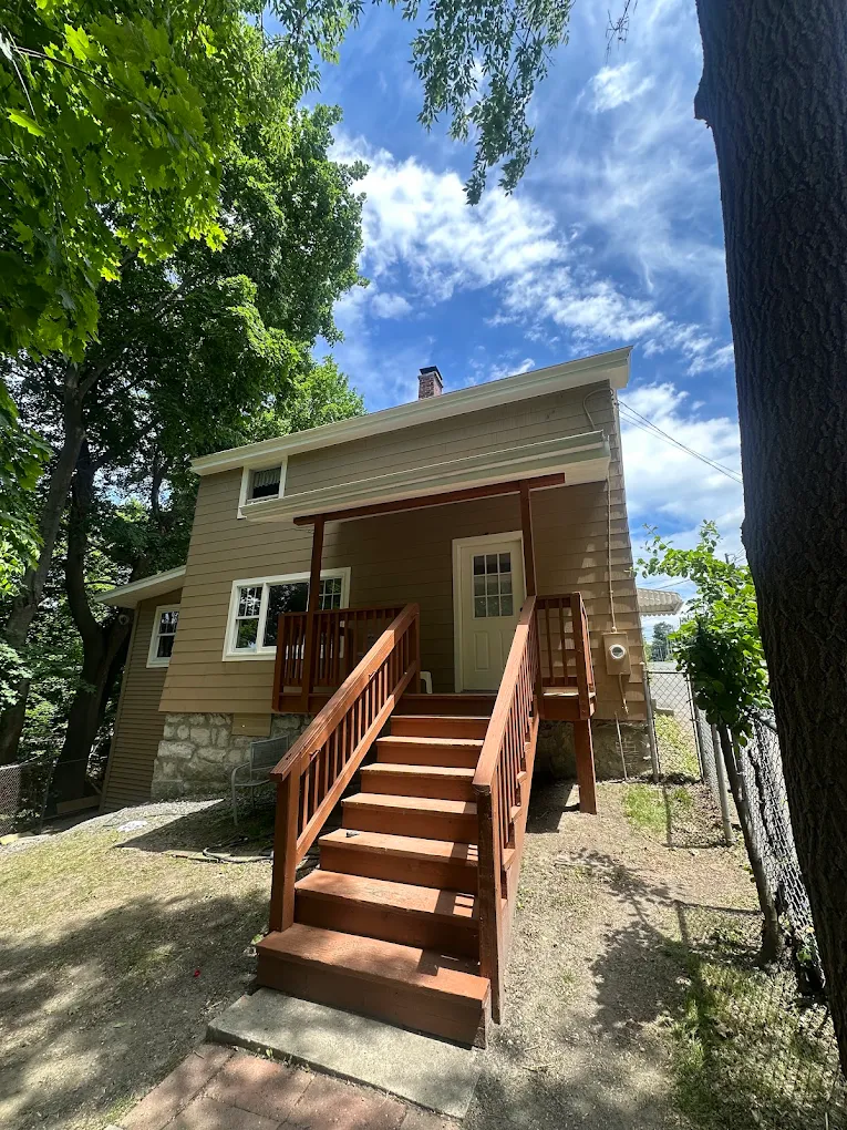 Tan home exterior with a freshly stained entry deck