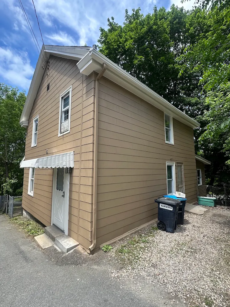 Two-story home with tan siding and white trim