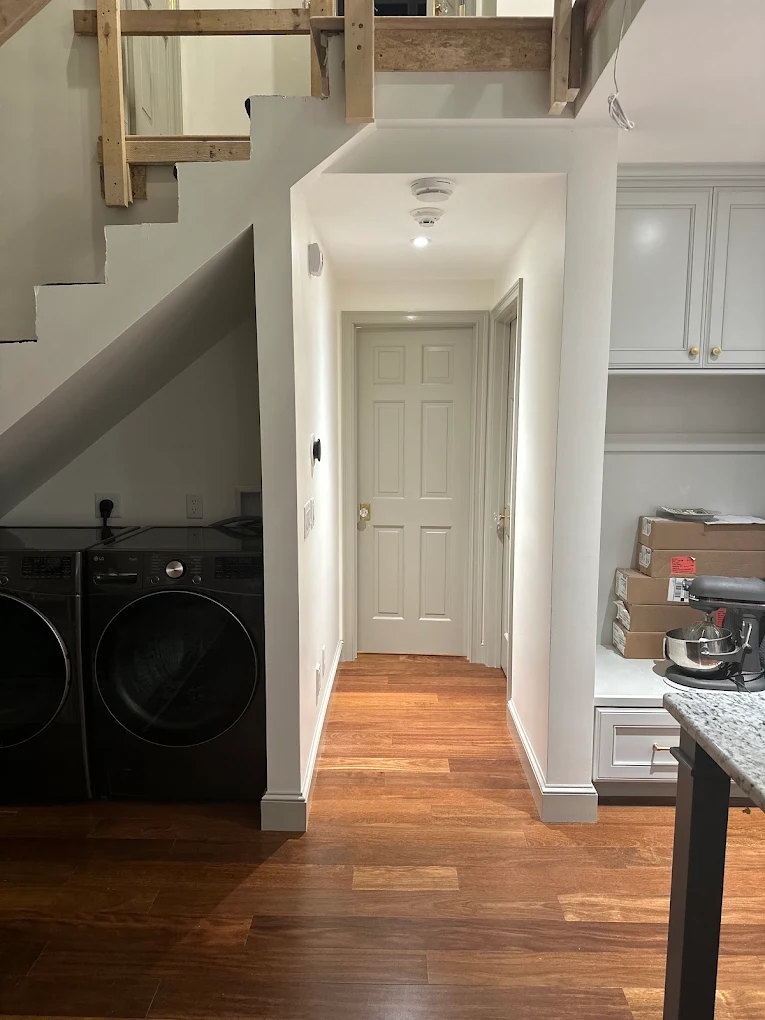 Bright hallway with white walls and gray paneled doors