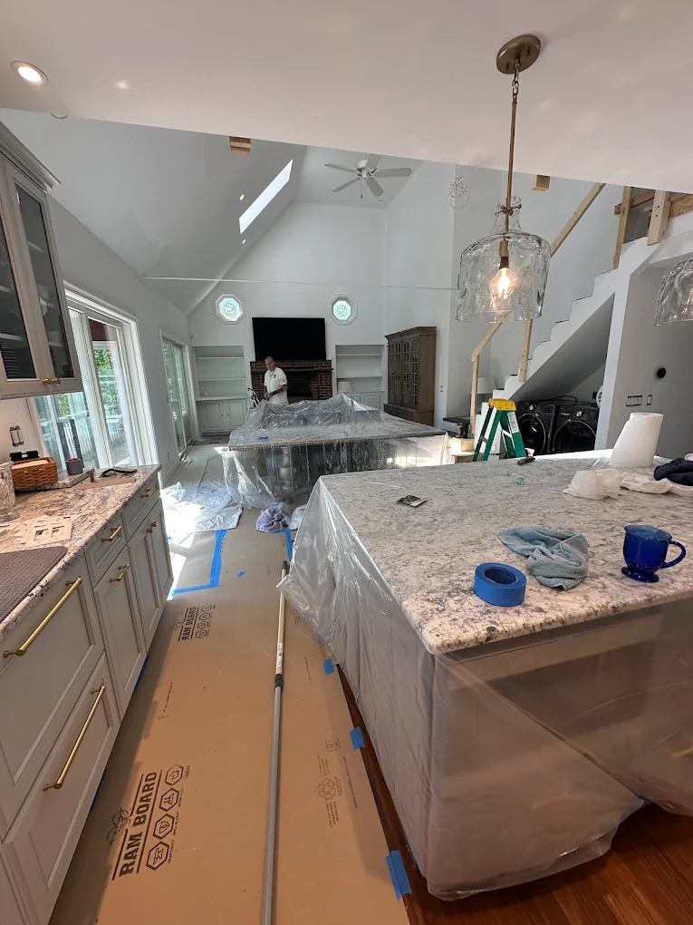 Kitchen island and floors covered with plastic and floor board