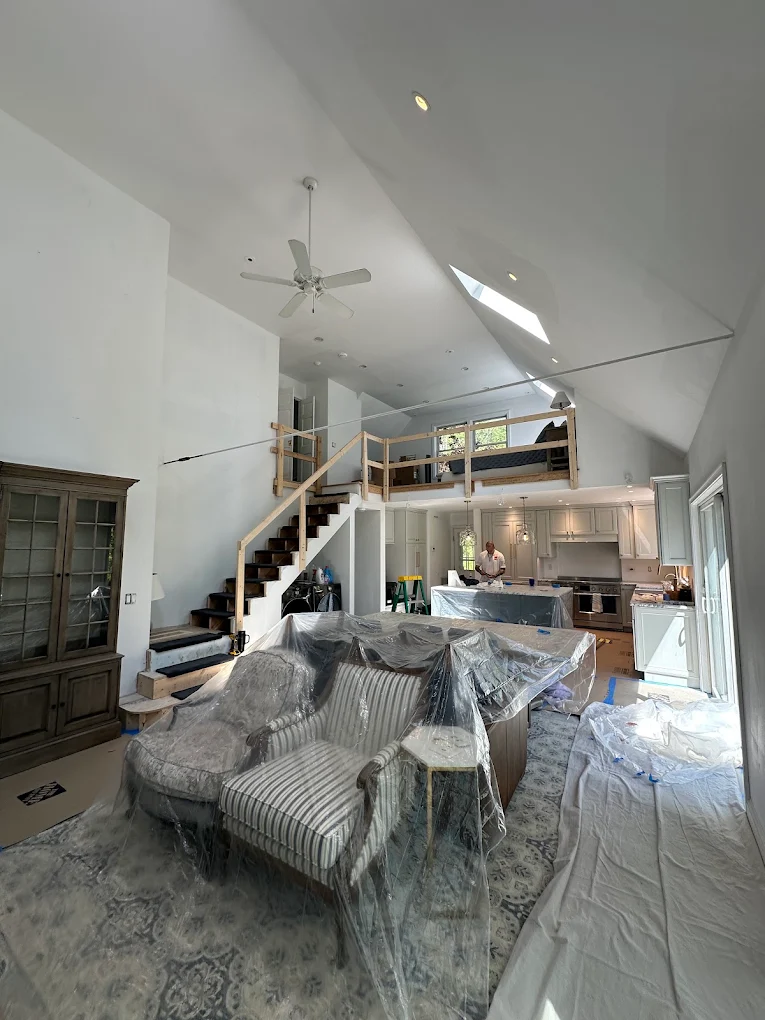 Open living space with furniture covered and floors protected