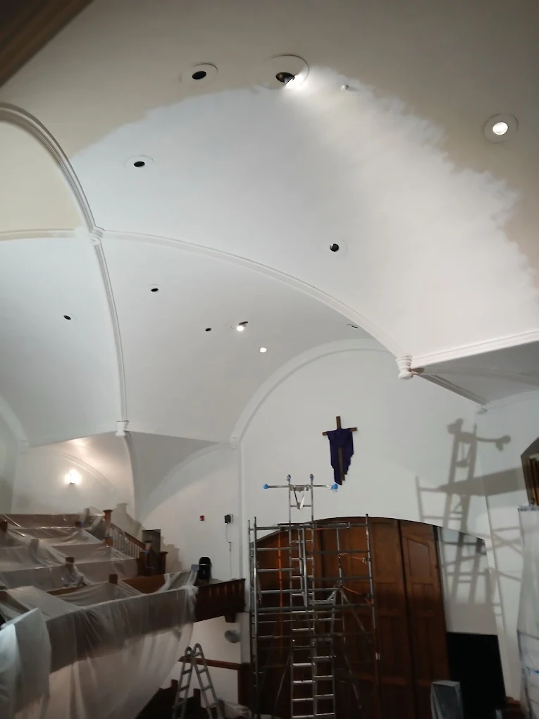 Church ceiling restoration with scaffolding and protected pews