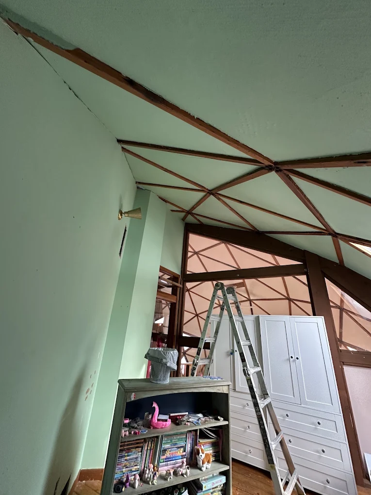 Ladder and supplies staged inside a geodesic dome room