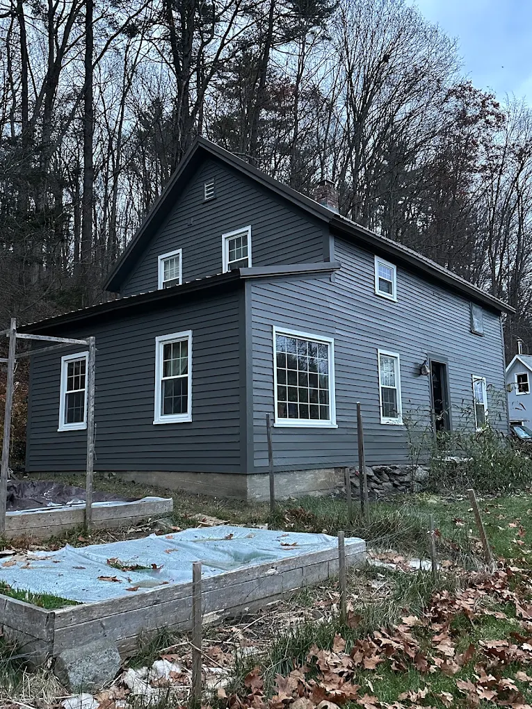Dark gray two-story farmhouse with crisp white windows