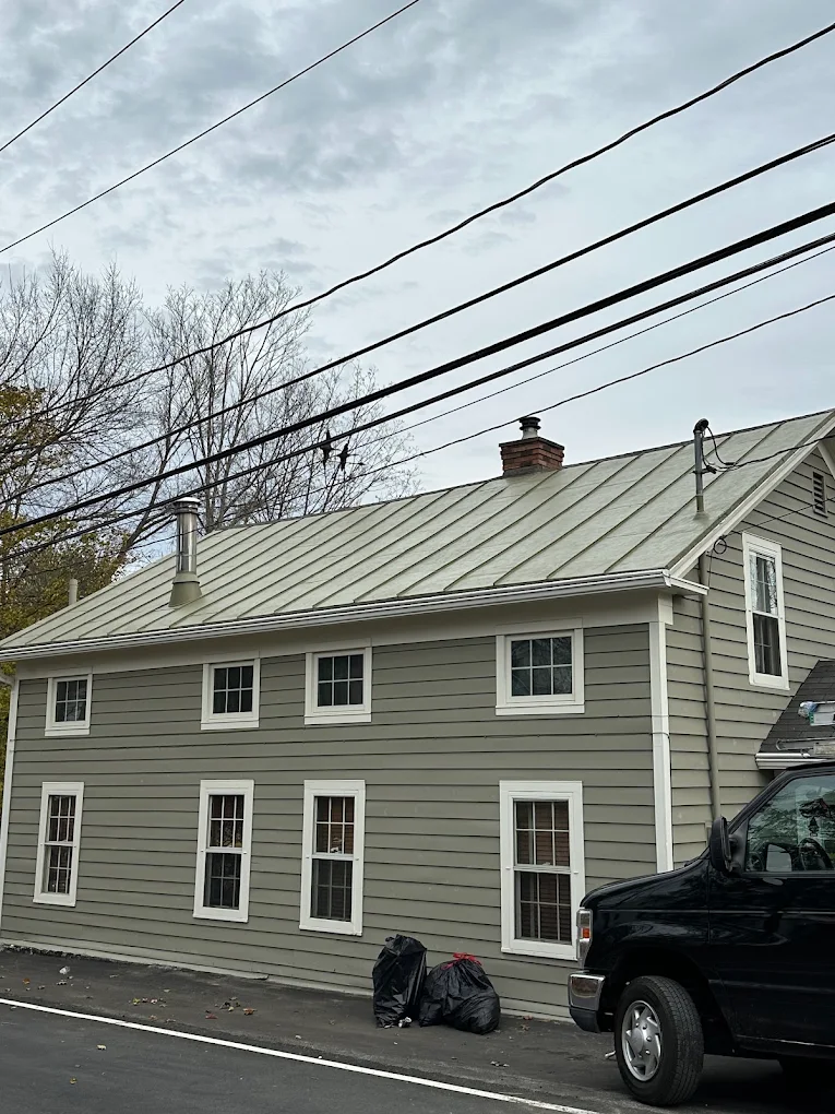 Freshly painted gray siding with crisp white trim on a Colonial home
