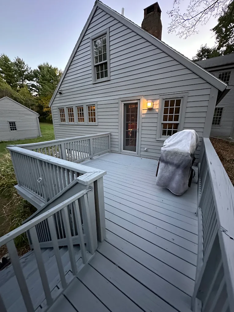 Gray Cape home and deck freshly painted at dusk