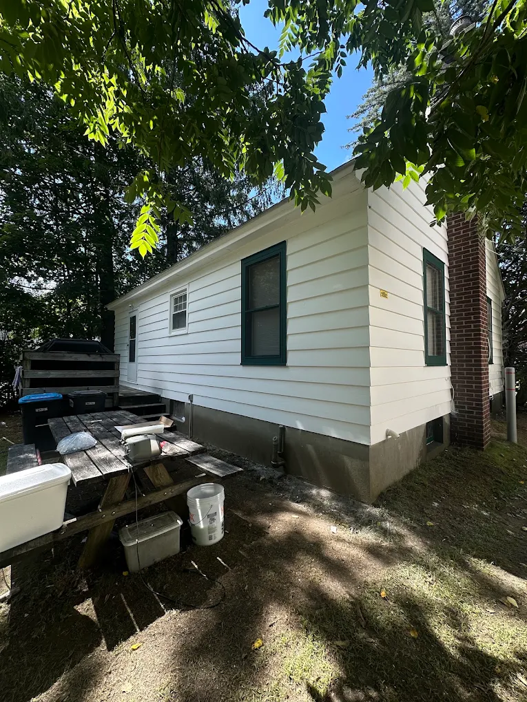 White-sided home with dark green window trim