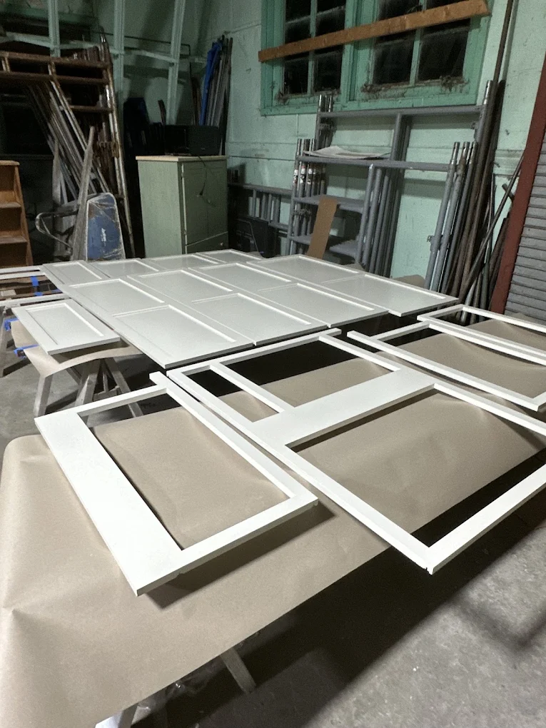 Freshly painted white cabinet doors drying in the shop